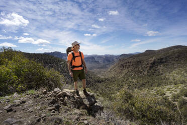 Mann genießt den Blick auf die Natur von einem Pfad über den Superstition Mountains - CAVF83521