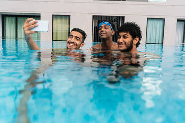 Teenagers making a selfie inside a pool surrounded - CAVF83613