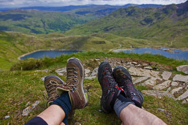 2 people's walking boots on a break on Snowdonia - CAVF83625