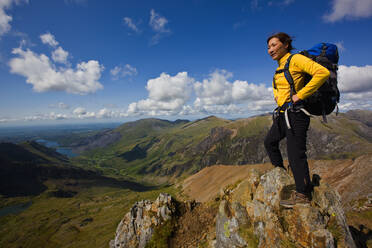 Frau mit Rucksack mit Blick auf den Snowdonia National Park - CAVF83628