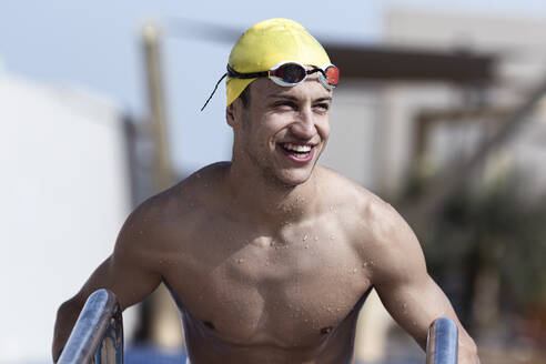 Glücklicher männlicher Schwimmer, der in einem Touristenzentrum wegschaut, Dubai, Vereinigte Arabische Emirate - SNF00263