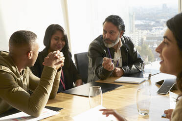 Business people talking in sunny conference room meeting - CAIF27528