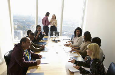 Business people talking in sunny conference room meeting - CAIF27543