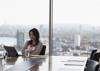 Geschäftsfrau mit digitalem Tablet im Konferenzraum eines Hochhauses - CAIF27619
