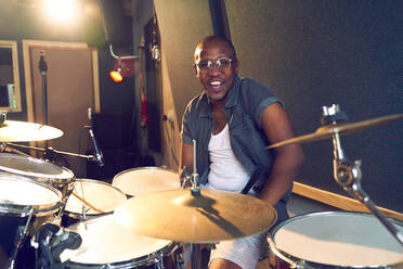 Portrait confident male drummer at drum kit - CAIF27672