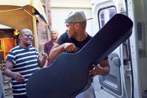 Musiker laden Gitarrenkoffer in Lieferwagen - CAIF27685