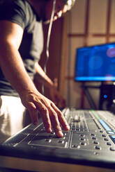 Man working at sound board in recording studio - CAIF27686