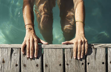 Frau schwimmt im Pool an einem sonnigen Tag - VEGF02330