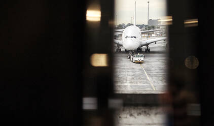 South Africa, Johannesburg, Airplane on tarmac seen from airport terminal - VEGF02337