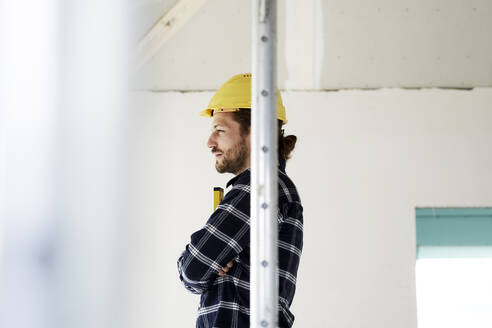 Nachdenklicher Arbeiter auf einer Baustelle - MJFKF00207