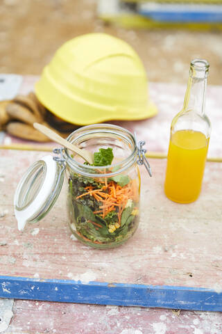 Salat zum Mitnehmen, Limonade und Schutzhelm auf der Baustelle, lizenzfreies Stockfoto