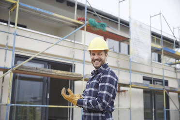 Porträt eines lachenden Arbeiters auf einer Baustelle - MJFKF00254