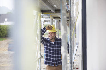 Porträt eines lächelnden Arbeiters auf einer Baustelle - MJFKF00255