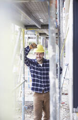 Porträt eines lächelnden Arbeiters auf einer Baustelle - MJFKF00256