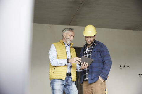 Architect and worker sharing tablet on a construction site stock photo