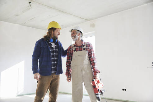 Construction workers with drill at construction site - MJFKF00297