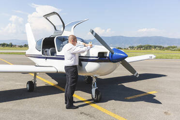 Pilot bei der Vorflugkontrolle seines Sportflugzeugs - WPEF02925