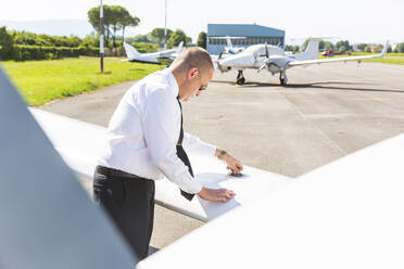 Pilot doing pre flight inspection on his sports plane - WPEF02927