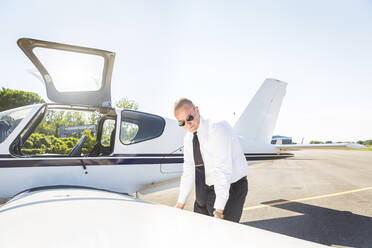 Pilot doing pre flight inspection on his sports plane - WPEF02928