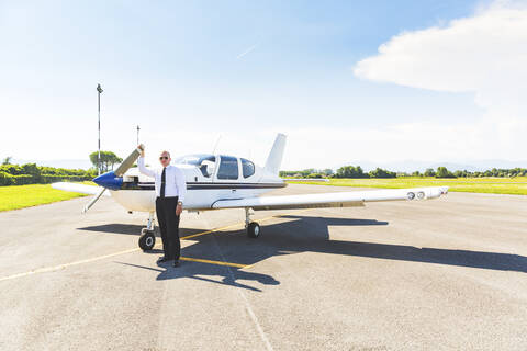 Pilot steht neben seinem Sportflugzeug, lizenzfreies Stockfoto