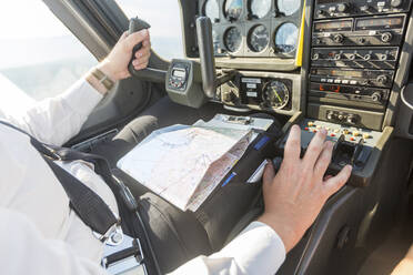 Pilot fliegt im Sportflugzeug, VFR-Karte auf dem Schoß - WPEF02939