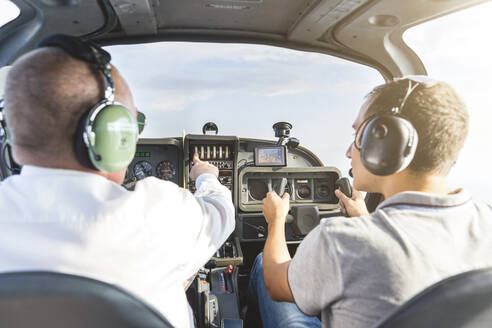 Pilot und Kopilot navigieren ein Sportflugzeug, Rückansicht - WPEF02945