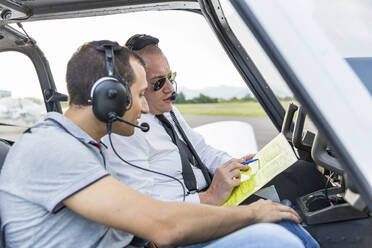 Flugzeug und Kopilot sitzen im Sportflugzeug und gehen die Checkliste durch - WPEF02950