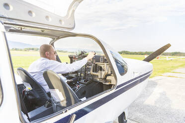 Pilot mit Headset, sitzend im Sportflugzeug - WPEF02954