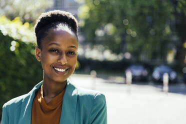 Portrait of smiling young businesswoman outdoors - MFF05788