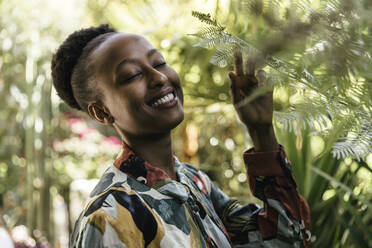 Portrait of happy young woman with eyes closed in nature - MFF05798