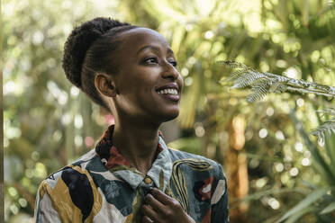 Portrait of happy young woman in a garden - MFF05800