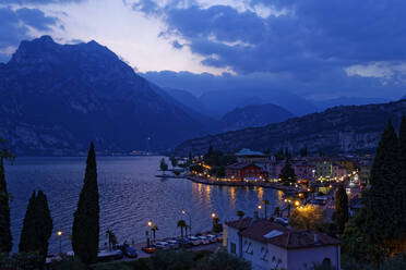 Italien, Trentino, Torbole, Gardasee, Stadt beleuchtet in der Abenddämmerung - UMF00929