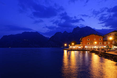Italien, Trentino, Torbole, Gardasee, Promenade und Stadt in der Abenddämmerung beleuchtet - UMF00930