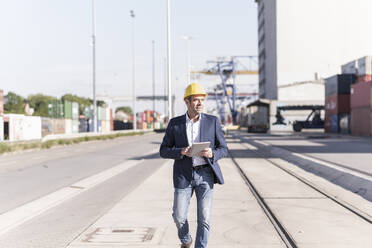 Geschäftsmann mit digitalem Tablet im Industriegebiet - UUF20425