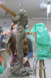Studentin, die Wasser auf eine Skulptur sprüht - FBAF01579