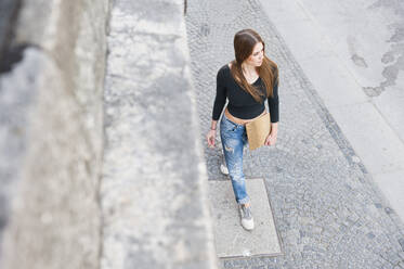 Fashionable woman walking on sidewalk in city - DIGF12505