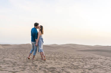 Couple kissing at sunset in the dunes, Gran Canaria, Spain - DIGF12555