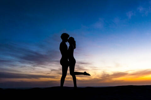Silhouette of affectionate couple kissing at sunset, Gran Canaria, Spain stock photo