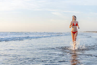 Frau im Bikini beim Laufen im Meer, Gran Canaria, Spanien - DIGF12591