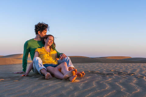 Verliebtes Paar sitzt bei Sonnenuntergang in den Dünen, Gran Canaria, Spanien, lizenzfreies Stockfoto