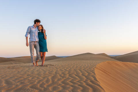 Verliebtes Paar beim Spaziergang durch die Dünen bei Sonnenuntergang, Gran Canaria, Spanien, lizenzfreies Stockfoto