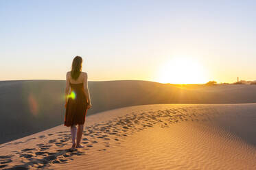 Frau in rotem Kleid bei Sonnenuntergang in den Dünen, Gran Canaria, Spanien - DIGF12605