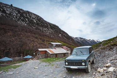 Georgia, Svaneti, Ushguli, Old car parked in front of house in medieval mountain village - WVF01746