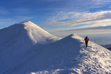 Italien, Provinz Pesaro und Urbino, Männlicher Wanderer auf dem schneebedeckten Gipfel des Monte Acuto - LOMF01143