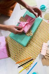 Hand of young woman wrapping present - GIOF08255