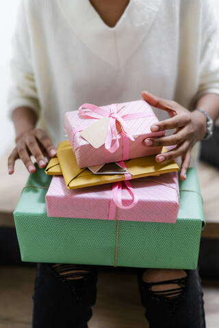 Young woman with stack of wrapped gifts stock photo