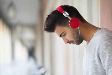 Junger Mann hört Musik über Kopfhörer - DIGF12644