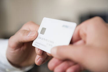 Man giving credit card to woman - DIGF12671