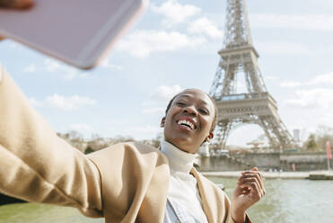 Glückliche Frau, die ein Selfie mit dem Eiffelturm im Hintergrund macht, Paris, Frankreich - KIJF03054
