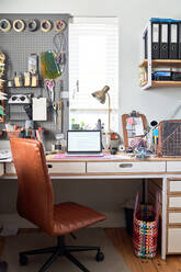 Laptop auf dem Schreibtisch im kreativen Heimbüro - CAIF27735